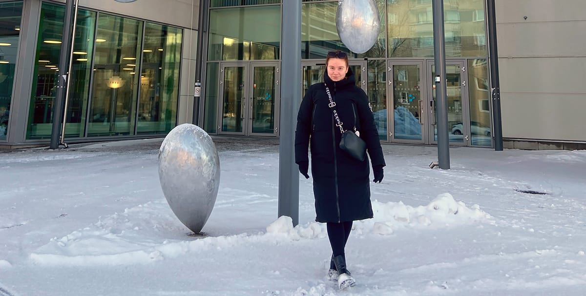 Annika Hasla seisoo lumisessa maisemassa SAMKin kampuksen edessä.