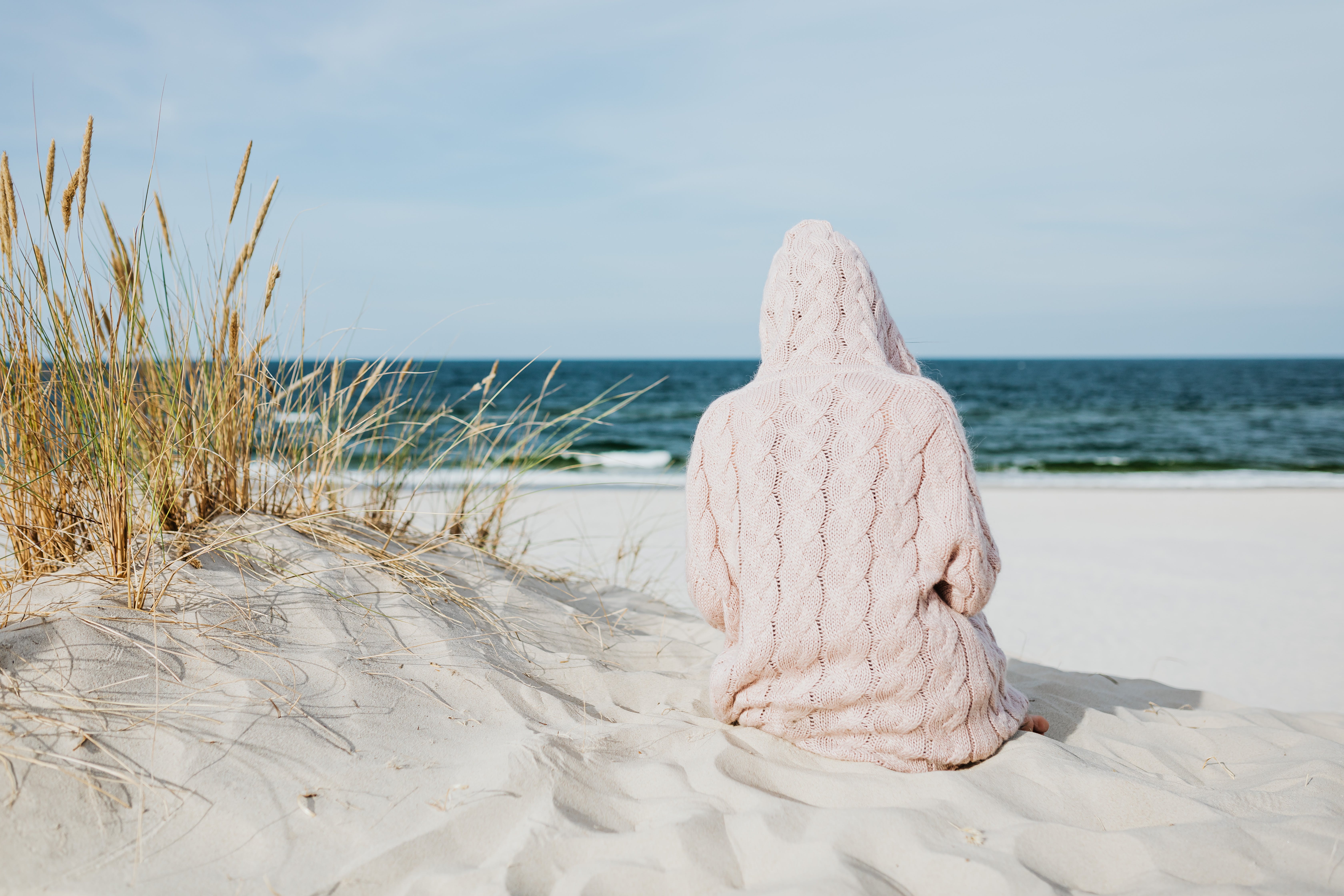 A person sitting on a sand beach