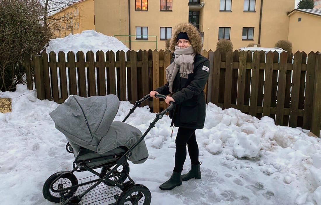 Joanna Sainio työntää lastenvaunuja pihalla talvella.