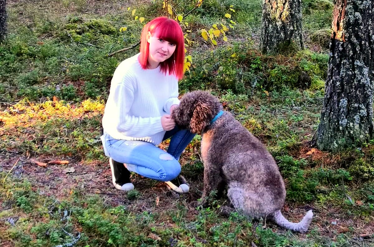 Jonna Hietakangas poseeraa koiransa kanssa metsässä.