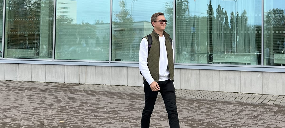Max Mäntylä kävelee kampuksen ulkopuolella.
