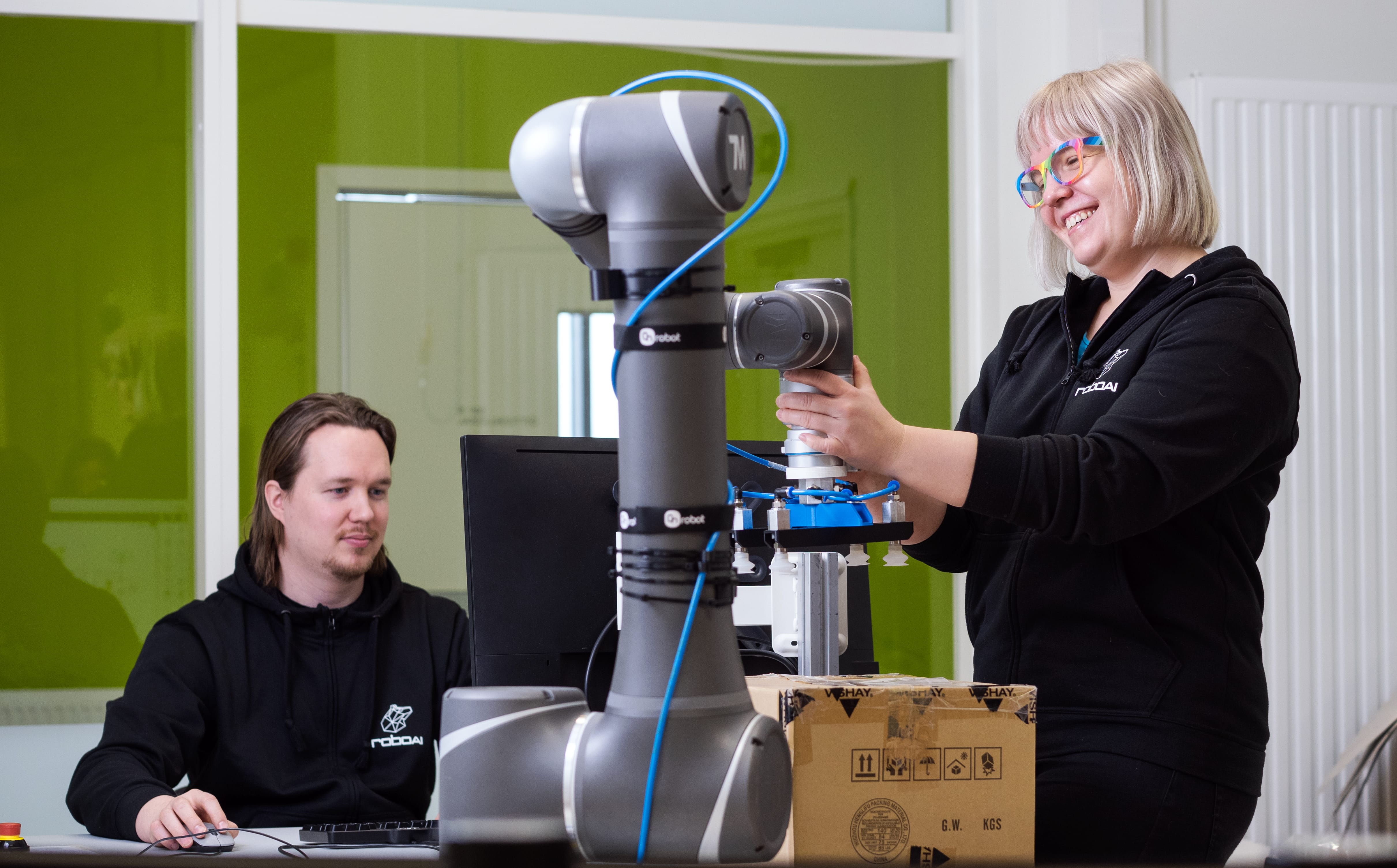 Two students use a collaborative robot.