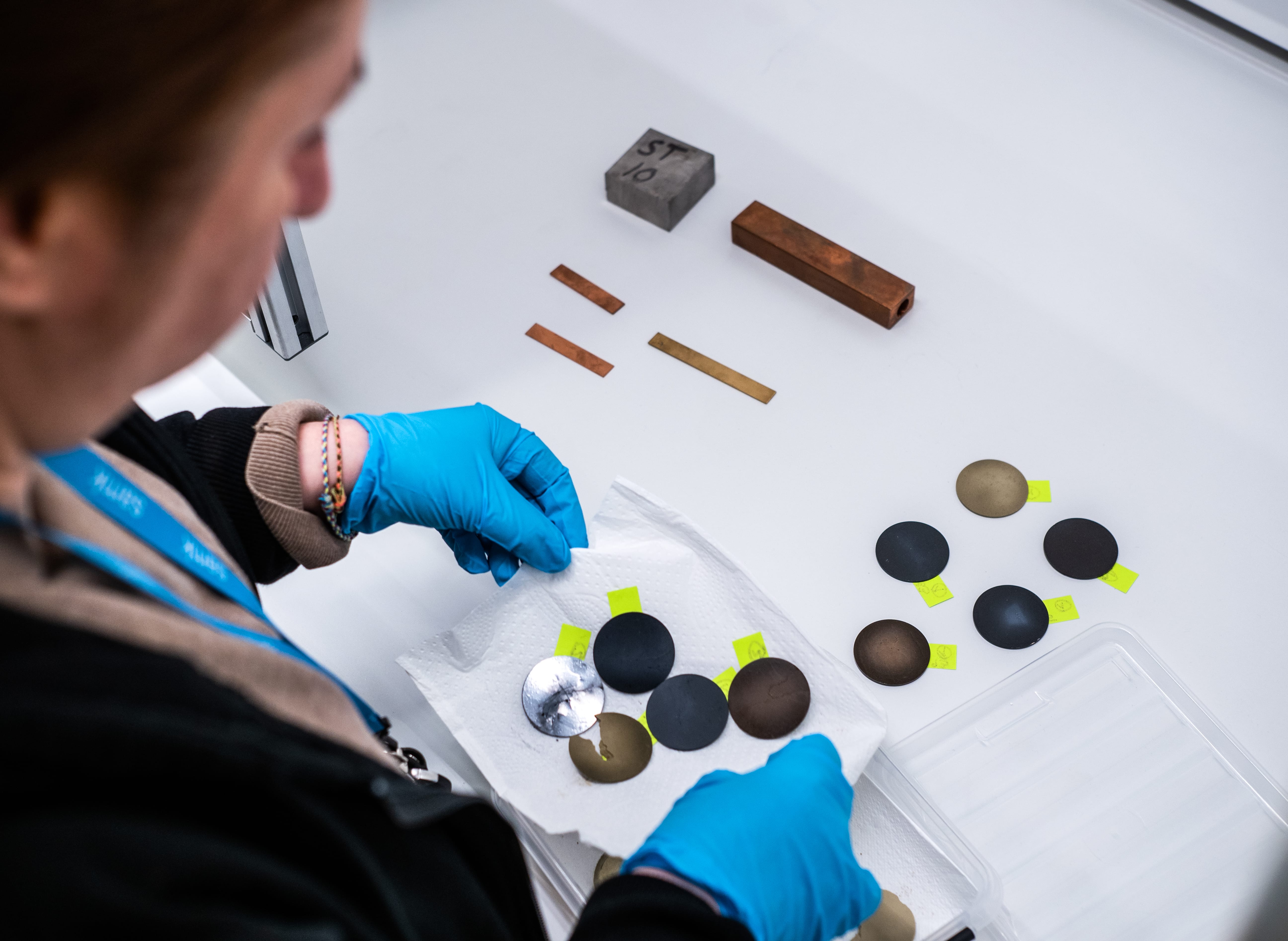 A person handles samples of different metal fractions.