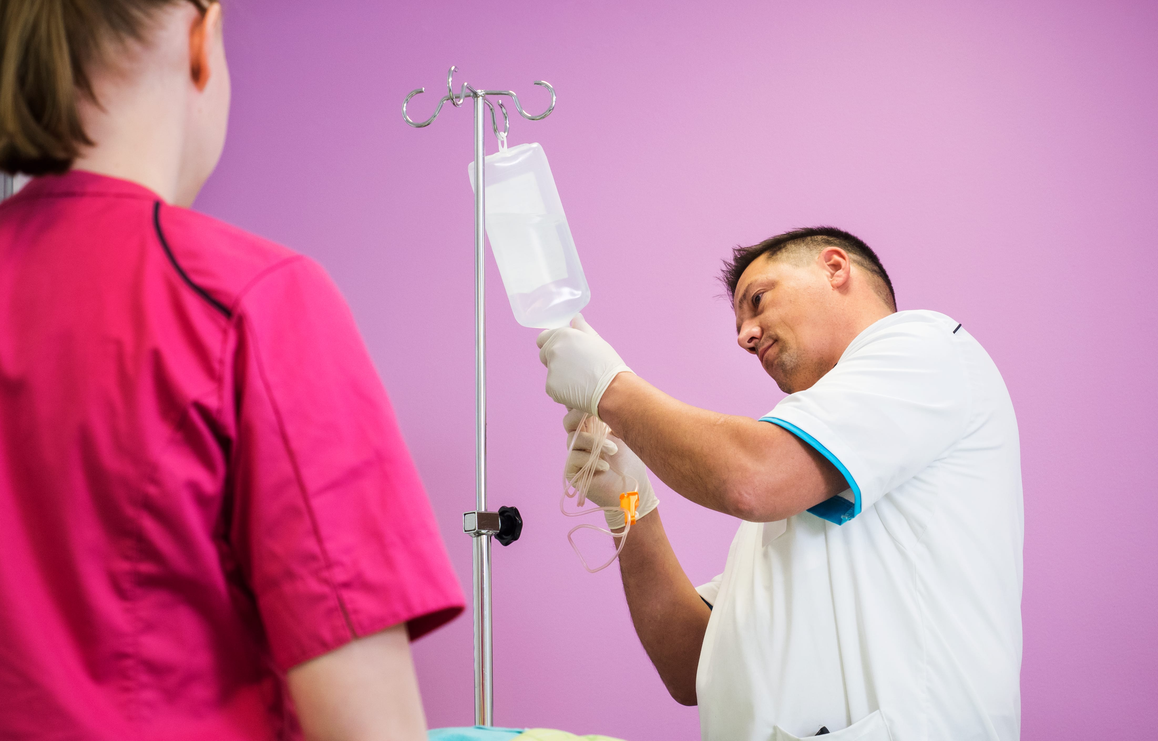 Nursing students practise inserting a cannula.