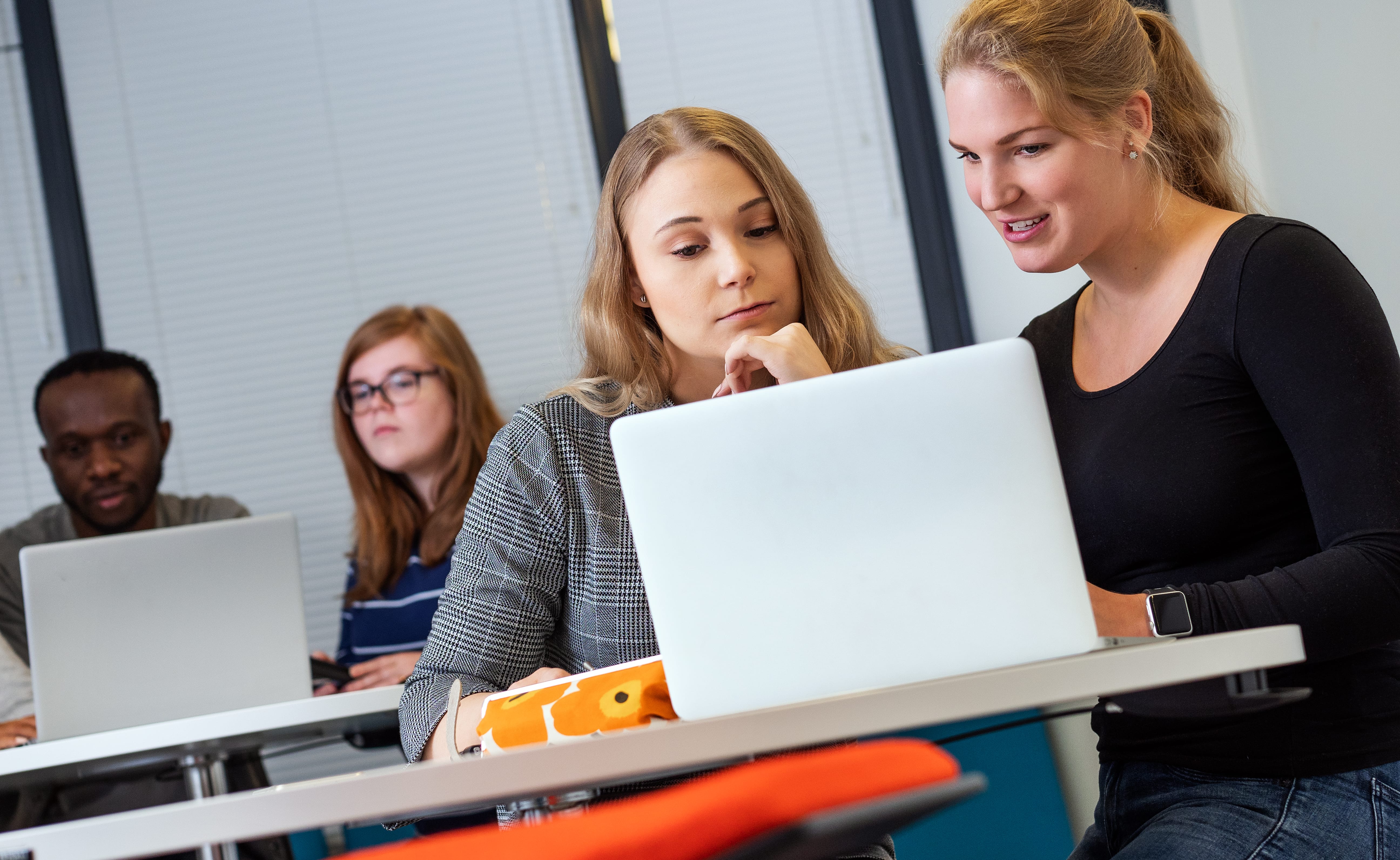 Students doing group assignments with laptops.