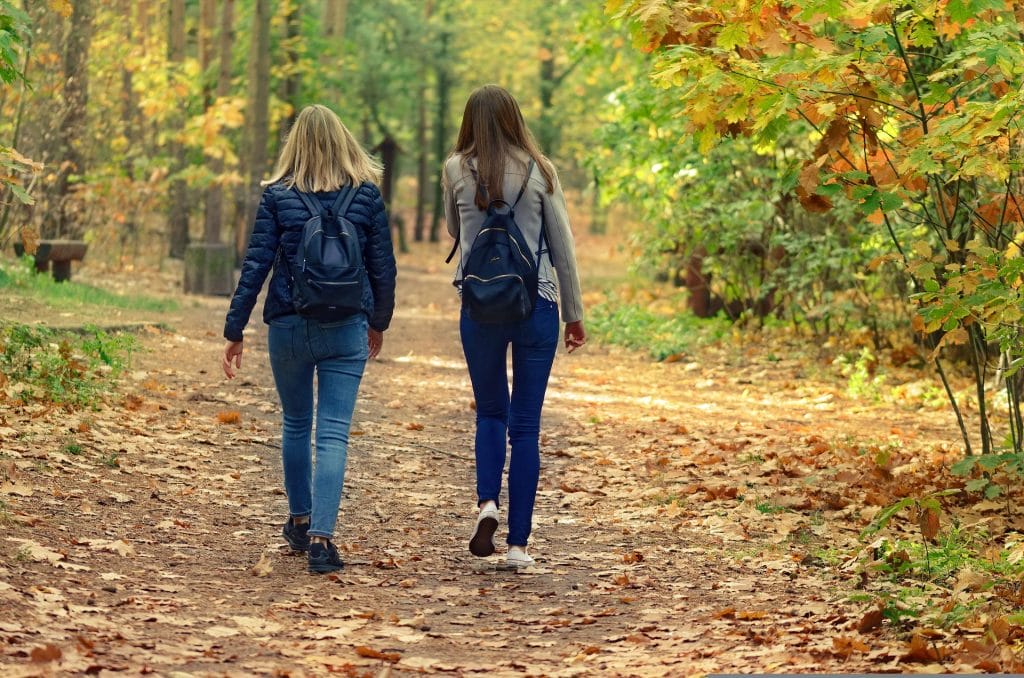 Two women walking in the forest.