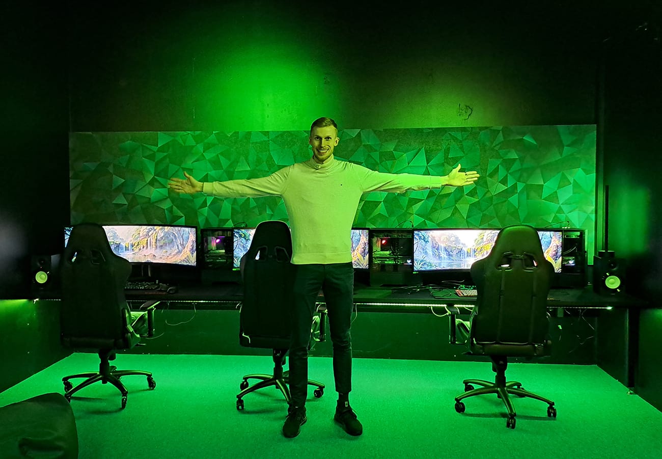 Tubettaja Roni Bäck seisoo kädet levitettyinä vihreänsävyisessä Pelisellissä.