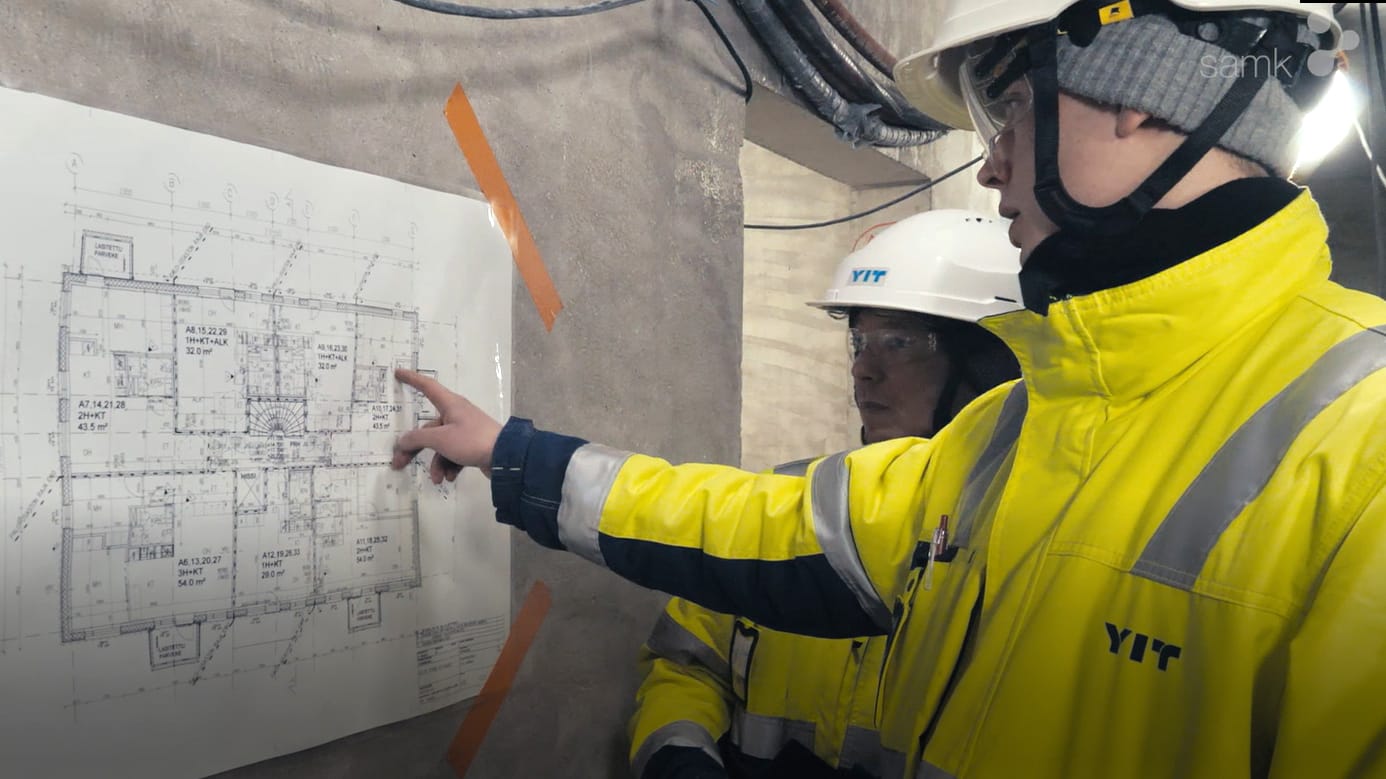Rakennustekniikan opiskelijat Jari-Petteri Joutsenlahti ja Tomi Ahokas katsovat rakennuspiirroksia rakennustyömaalla.