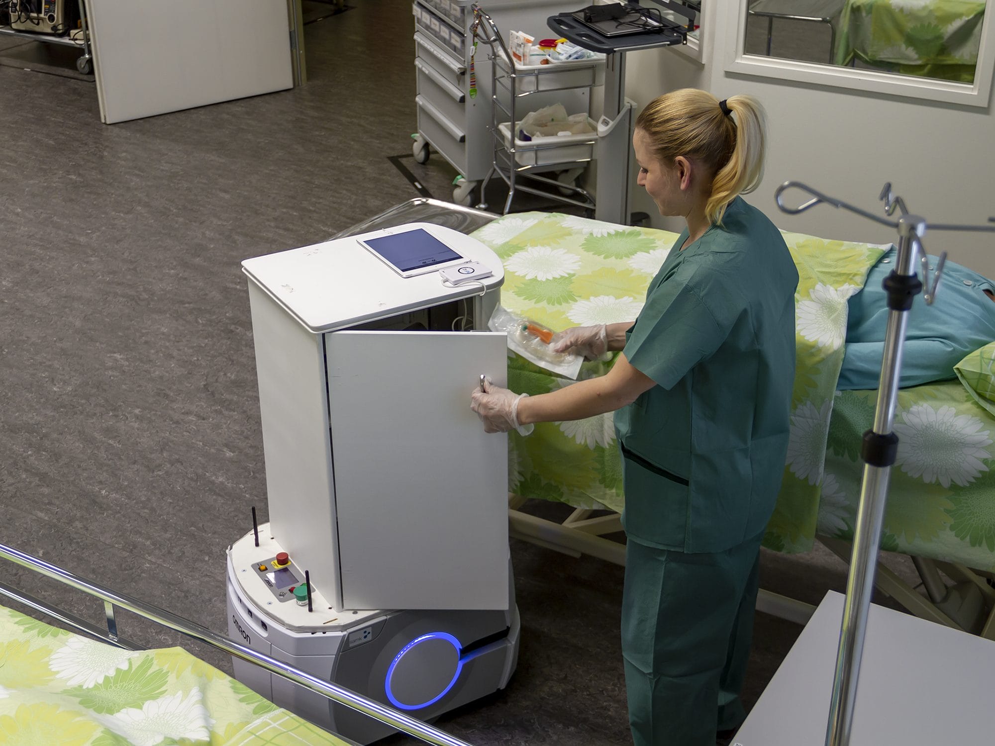 A mobile robot assists the nurse in her work.