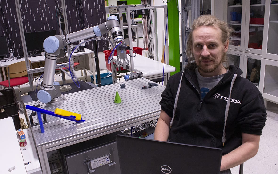Student programming a robot at automation laboratory.